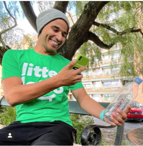 A photograph of a person picking-up litter and using the app on their smartphone.